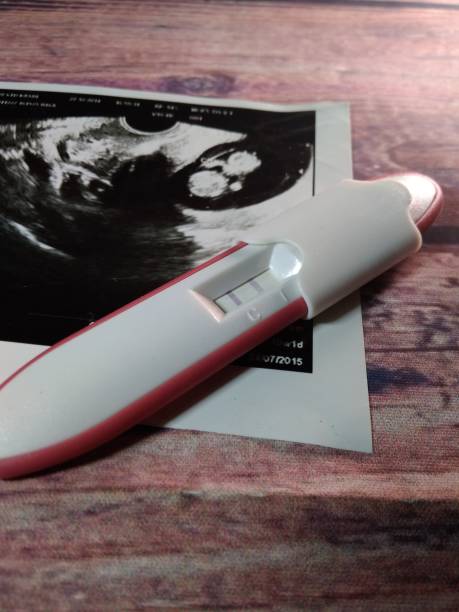 istock pregnancy test pack positive result at wooden table 1056510658