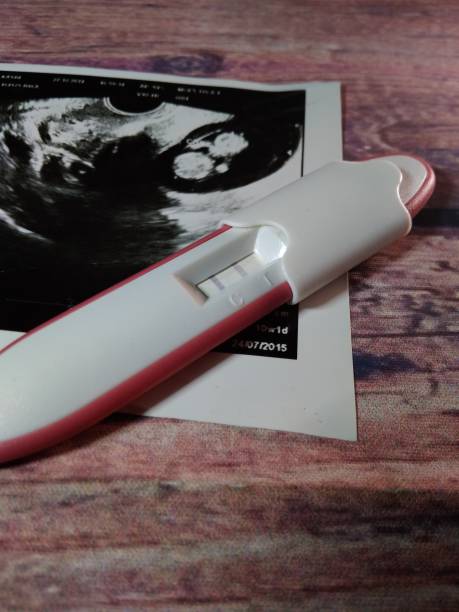 pregnancy test pack positive result at wooden table