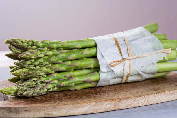 Bunch of fresh uncooked green asparagus vegetables ready to cook Bunch of fresh uncooked green asparagus vegetables ready to cook close up asparagus organic dinner close to stock pictures, royalty-free photos & images