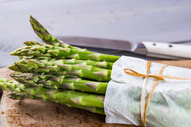 Bunch of fresh uncooked green asparagus vegetables ready to cook Bunch of fresh uncooked green asparagus vegetables ready to cook close up asparagus organic dinner close to stock pictures, royalty-free photos & images