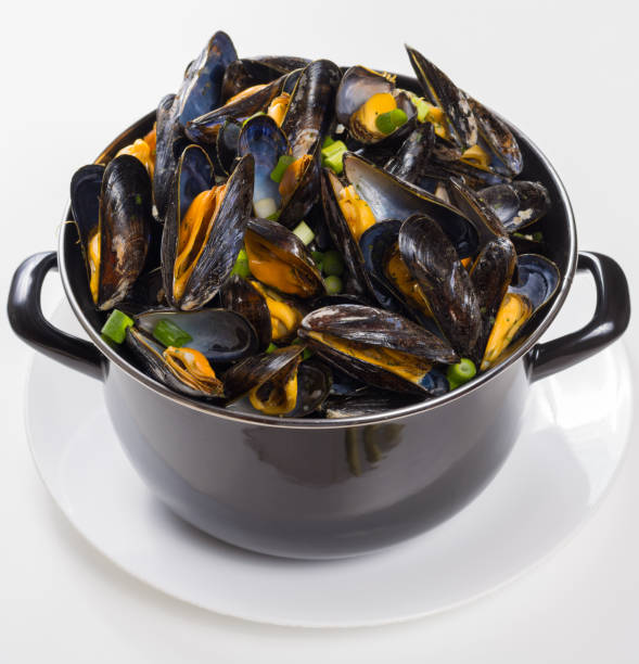 istock Black pan with cooked with green onion, parsley marinated high quality mussels 1056512022