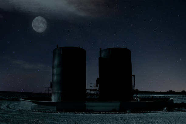 Night scene of bitumen tanks under a moon lit sky