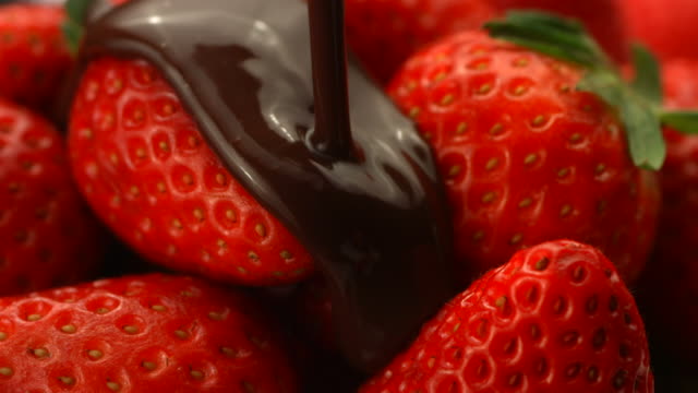 Chocolate onto strawberries, slow motion