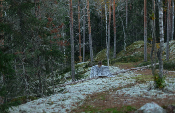 istock girl with white wings in the forest 1056520188