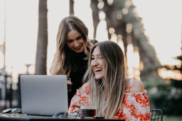 istock Two beautiful females drinking coffee and web surfing 1056521724