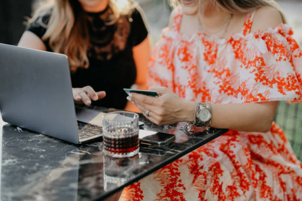 istock Two beautiful females drinking coffee and web surfing 1056523294