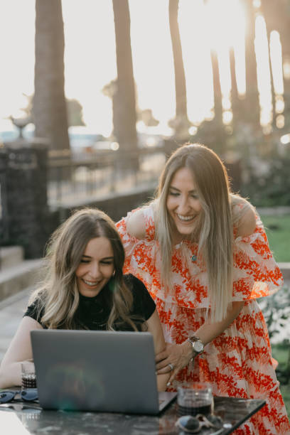 istock Two beautiful females drinking coffee and web surfing 1056526034
