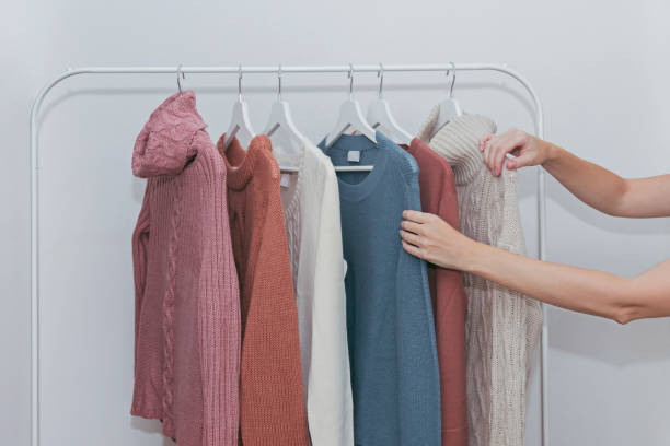 istock Woman choosing pastel warm cozy sweaters on hangers 1056535444