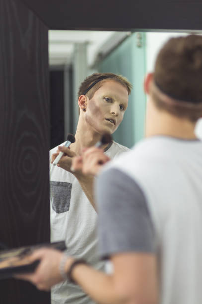 istock Man gets dressed in drag attire in bathroom 1056537484