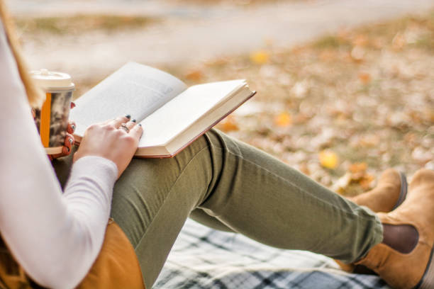 istock Girl with book on legs reading at retro blanket 1056539352