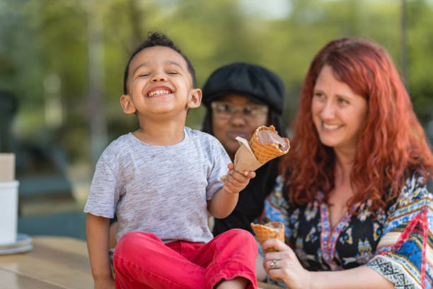 istock Two moms eat ice cream with their three-year old son 1056539400