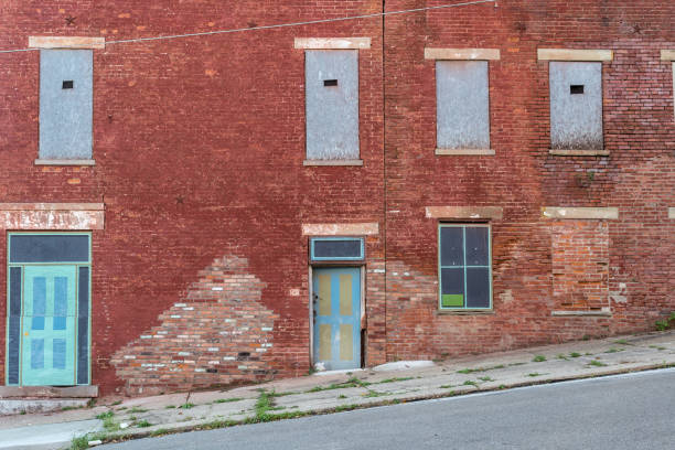 mit an bord, bis windows gebäude aus rotem backstein abgenutzt - poverty ugliness residential structure usa stock-fotos und bilder