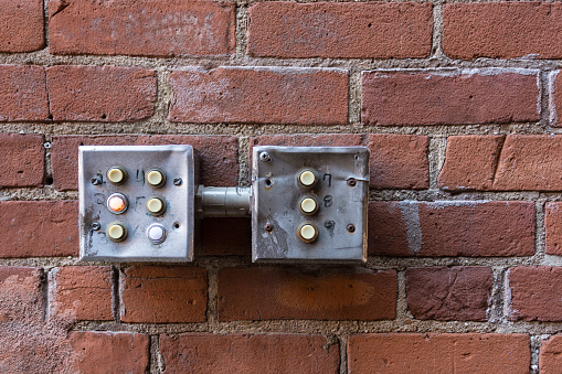 Buttons attached to brick wall in urban environment
