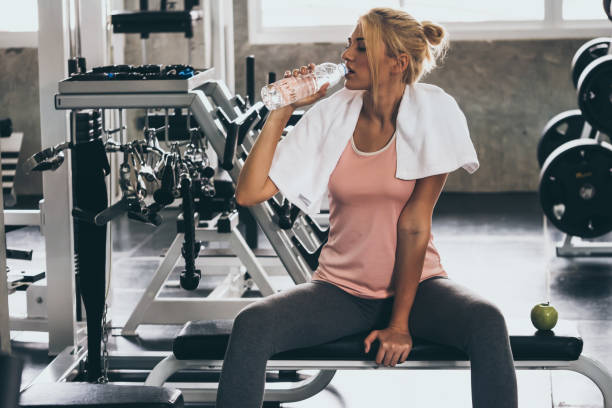 istock Attractive young woman taking a break after exercise at the gym 1056579080