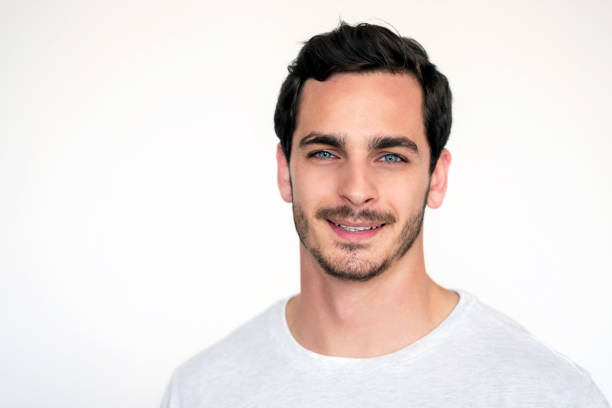 Close-up portrait of attractive young man with beard starting against white background