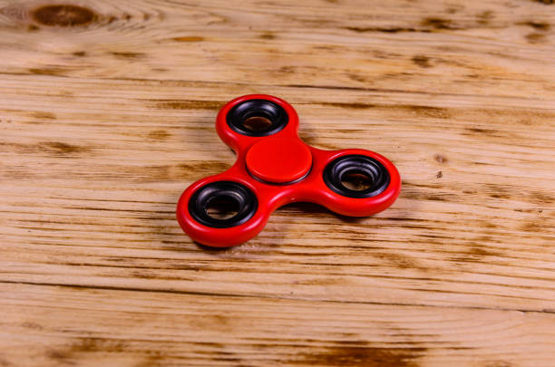 istock Red fidget spinner on wooden desk 1056607996