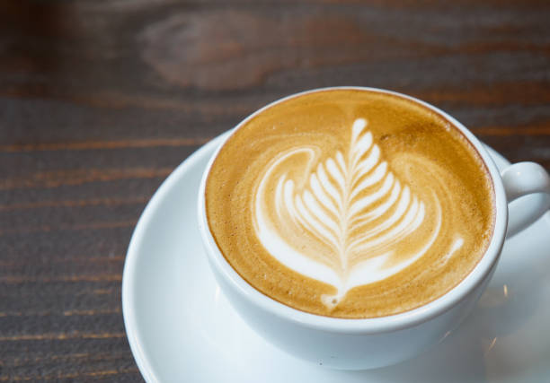 istock close up latte art coffee on wooden background, beverage concept. 1056608546