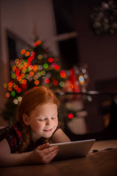 istock Smiling young girl using digital tablet at home 1056613236