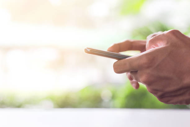 istock Close-up Man using  Mobile Phone outdoor park  with copy space for text . 1056613516