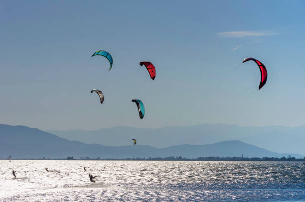 istock Colored kite surfers on riding waves on mediterranean sea 1056613968