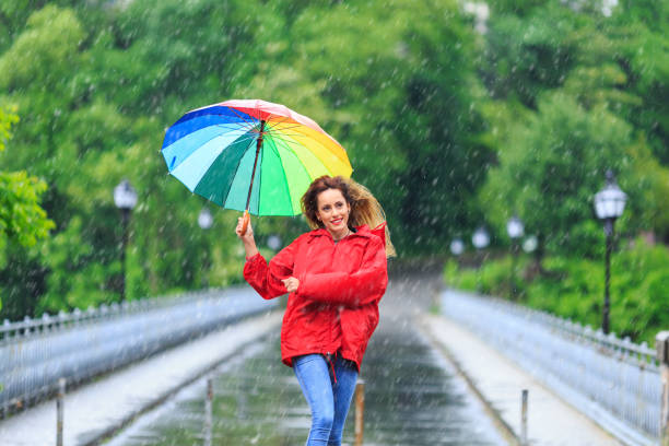 istock Woman with umbrella having fun in rainy day 1056617264