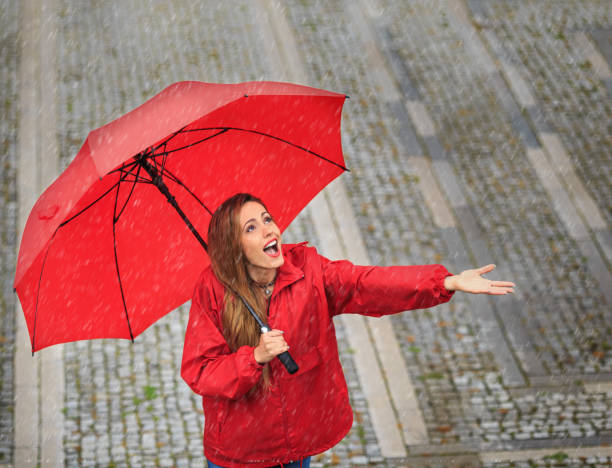 istock Woman with umbrella having fun in rainy day 1056617266