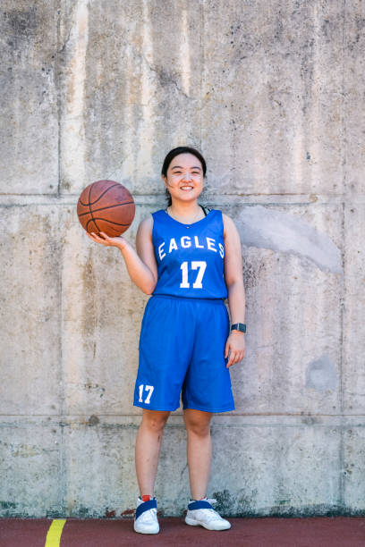 istock Confident player holding basketball against wall 1056617278
