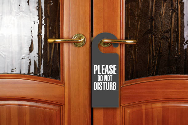 istock Closed door with sign PLEASE DO NOT DISTURB on handle at hotel 1056618628