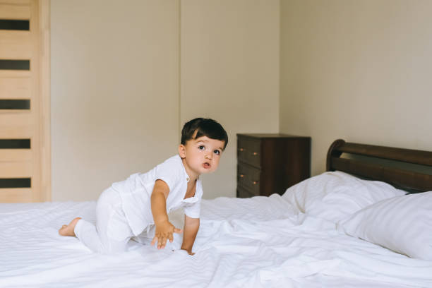 istock adorable little kid in white clothes crawling on bed 1056625810