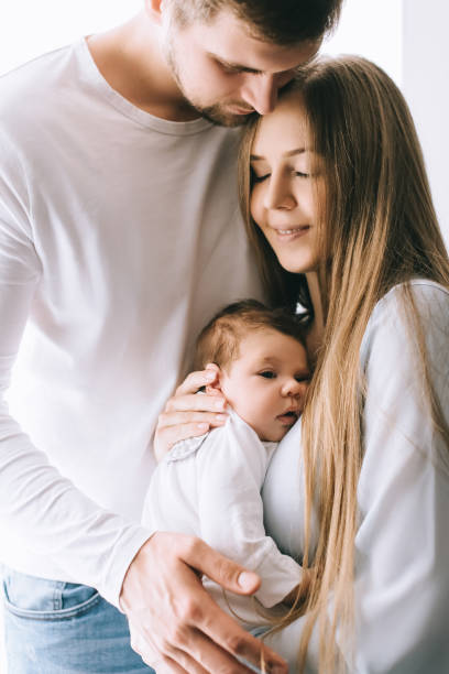 porträt der familie mit kleinen jungen vor vorhänge zu hause - baby beautiful little boys carrying stock-fotos und bilder