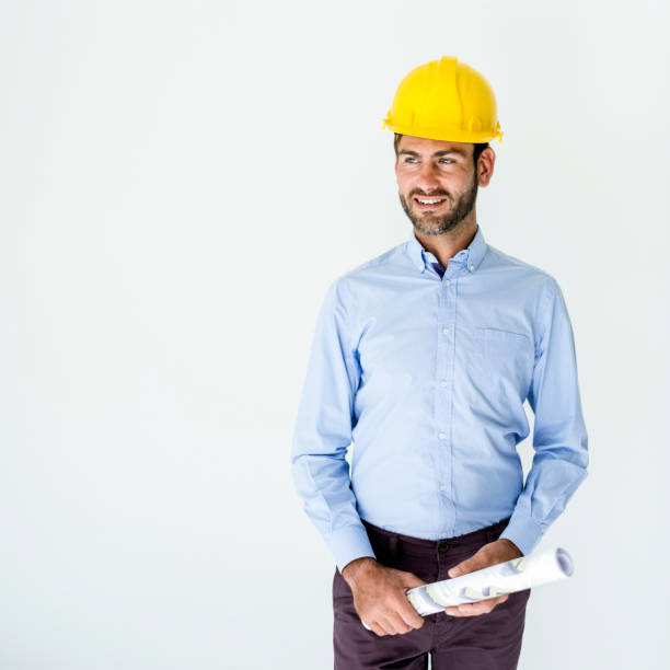 istock Smiling male architect with blueprint looking away 1056628518