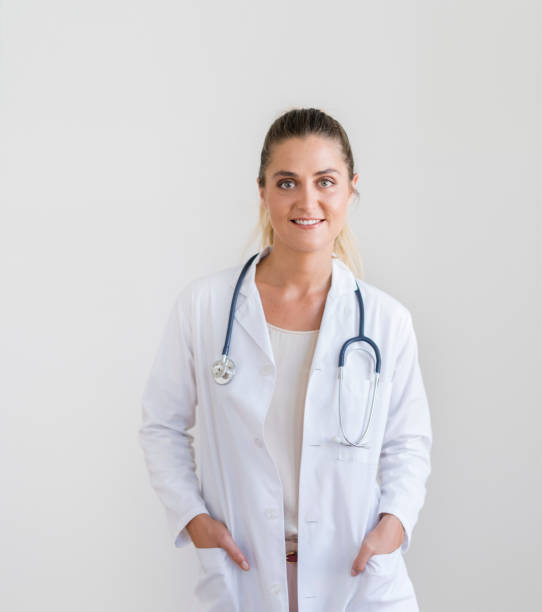 istock Smiling young female doctor with hands in pockets 1056630204