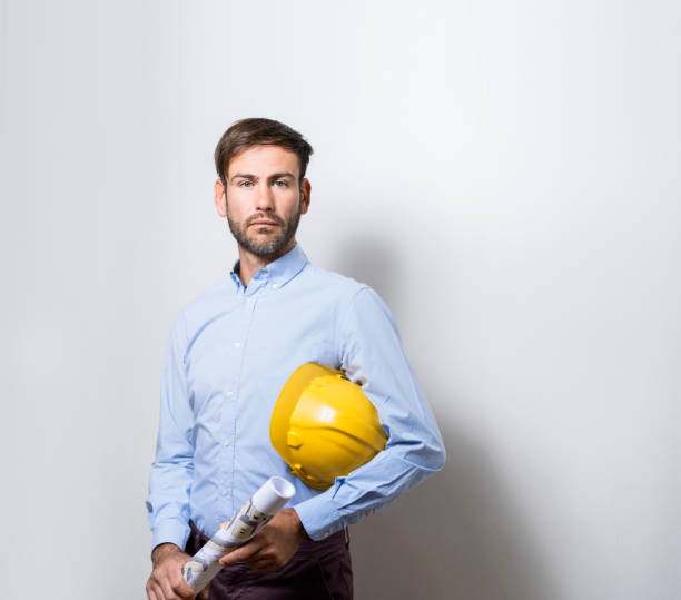 istock Male architect holding blueprint and hardhat 1056631756