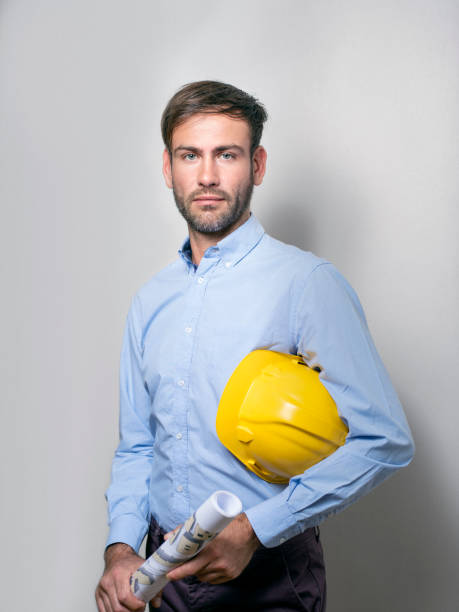 istock Male engineer holding blueprint and hardhat 1056631766