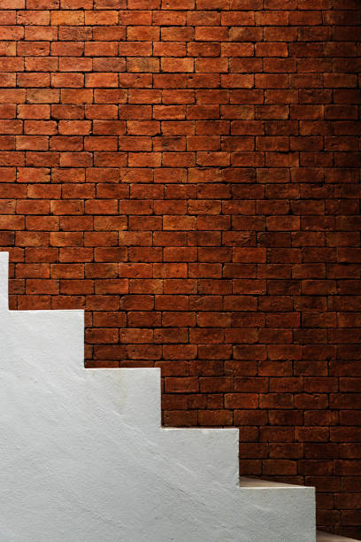 istock Red brick wall and white concrete stairway 1056632300