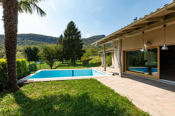 istock Villa with pool and surrounded by green lawn on a summer day 1056632344