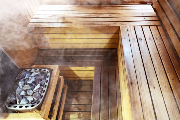 Interior of small home Finnish wooden sauna. Infrared sauna. Cedar bath. beautiful nature interior home finnish sauna room background. inside the sauna. Hot stones in the bath.
