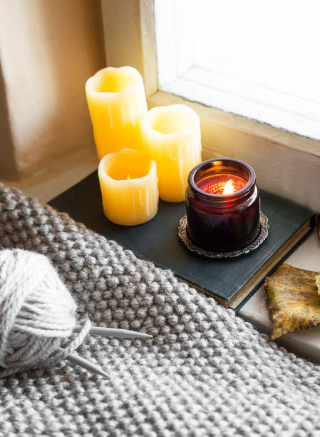 istock Winter or fall candles at window with knitting tools and wool blanket, fall indoor setting, cozy fall knitting leisure 1056640192