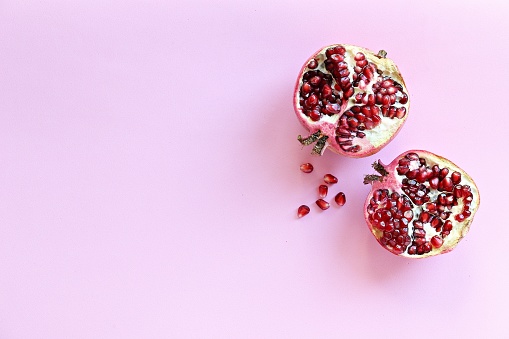 Pomegranate. Fresh ripe pomegranate overhead light pink background. Top view, copy space