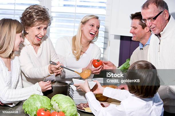 Nonna Con La Sua Famiglia Ridere In Cucina Servire Il Pranzo - Fotografie stock e altre immagini di 10-11 anni