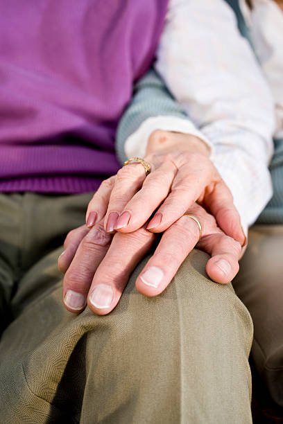 istock An elderly woman's hand on an elderly man's hand on his knee 105664492