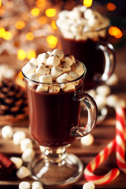 istock Cappuccino with marshmallow in glasses and candy cane on wooden table 1056646256