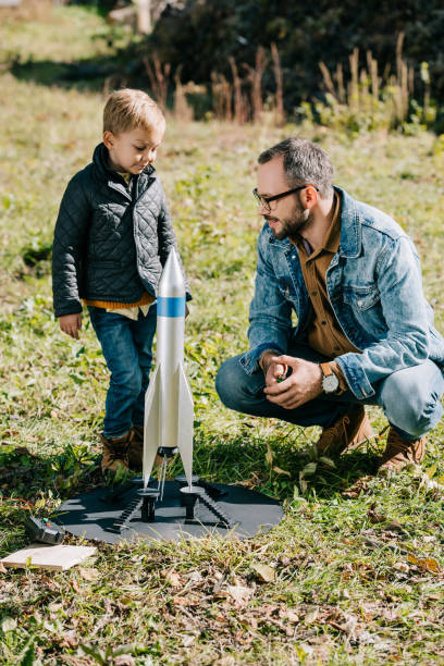 istock happy father and cute little son playing with model rocket outdoor 1056656324