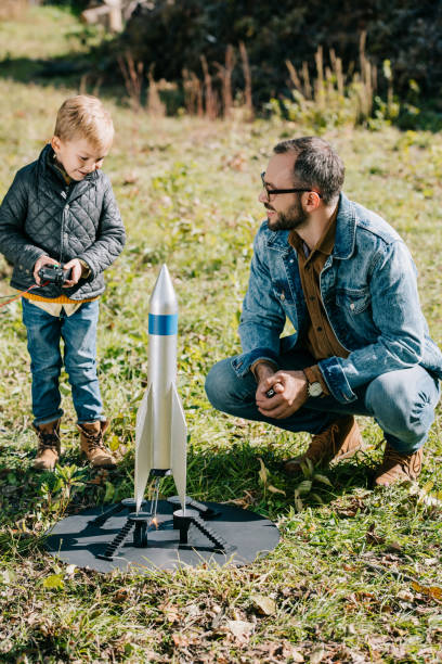 istock happy father and little son launching model rocket outdoor 1056656338