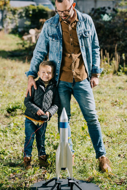 istock happy father with little son smiling at camera while playing with model rocket outdoor 1056656342