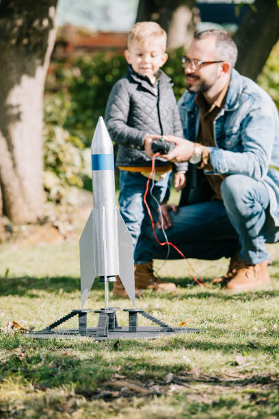 istock close-up view of model rocket and father with son playing behind 1056656346