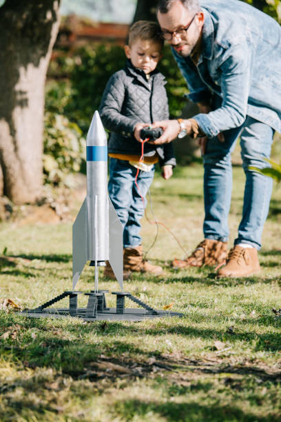 istock father and son launching model rocket together at sunny day 1056656350