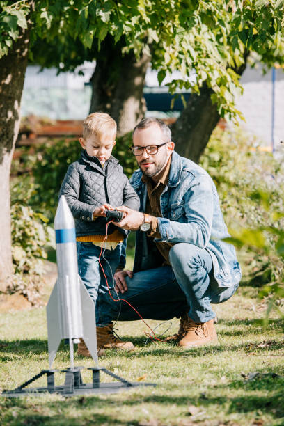 istock happy father and son launching model rocket together at sunny day 1056656370