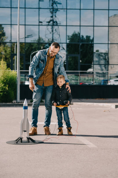 istock happy father and son looking at model rocket launch outdoor 1056656396