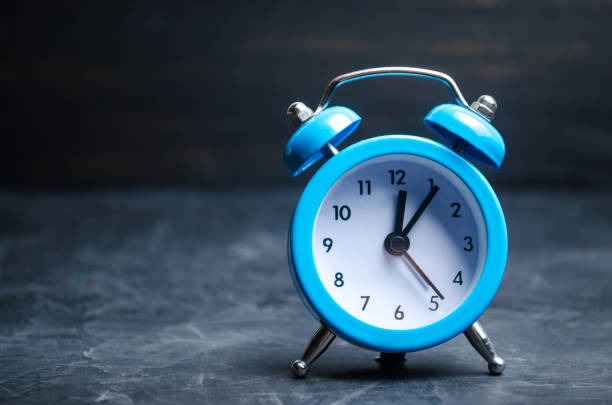istock The blue alarm clock indicates the beginning of the first on a black background. time management. concept of the flow of time. copy space. minimalist style. 1056657740